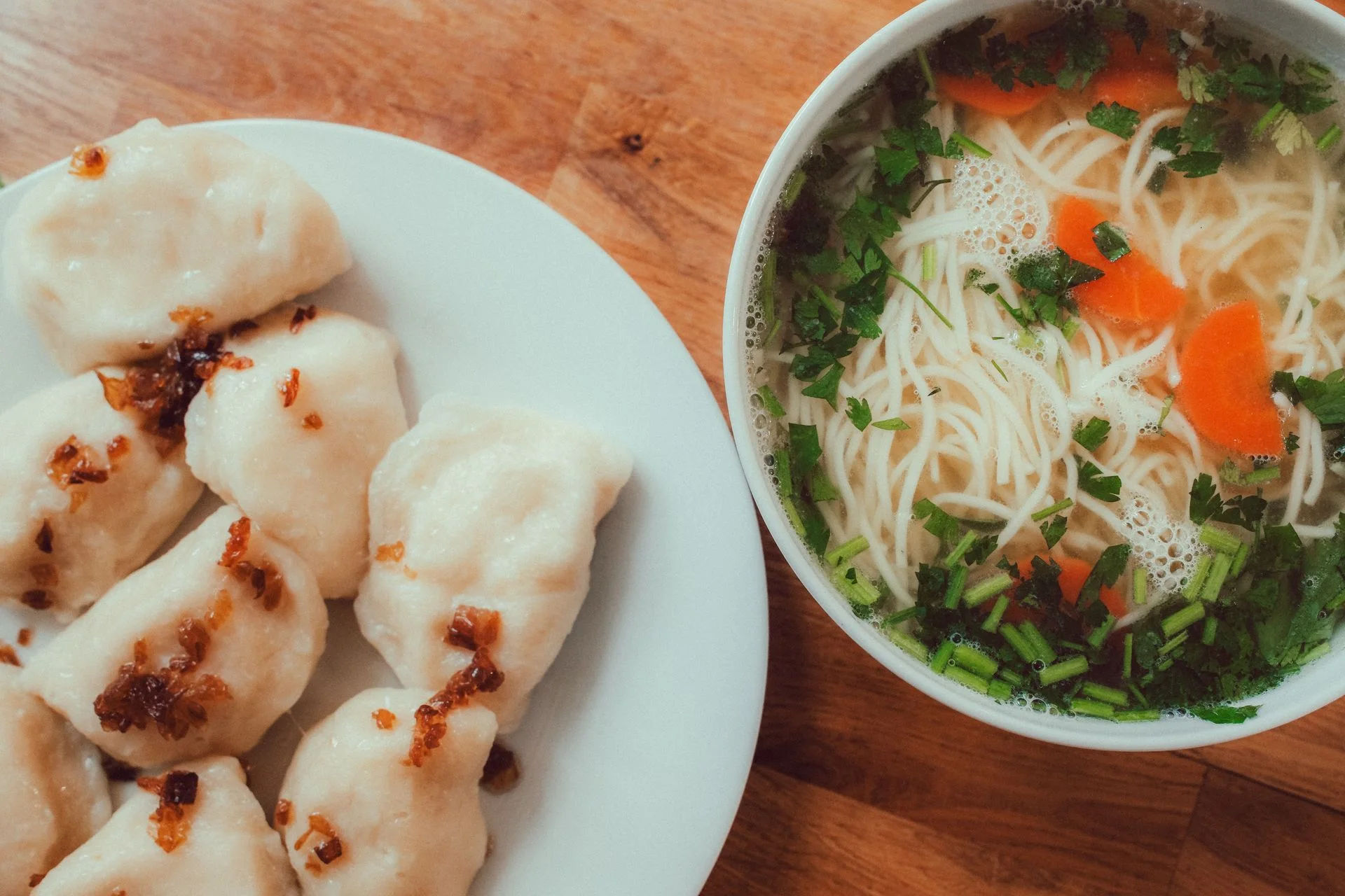 Rosół i pierogi podane na jasnym stole